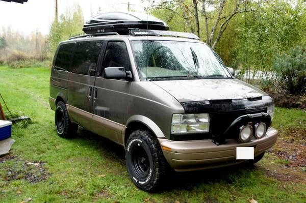 the van is parked in the yard with its roof rack on it's back