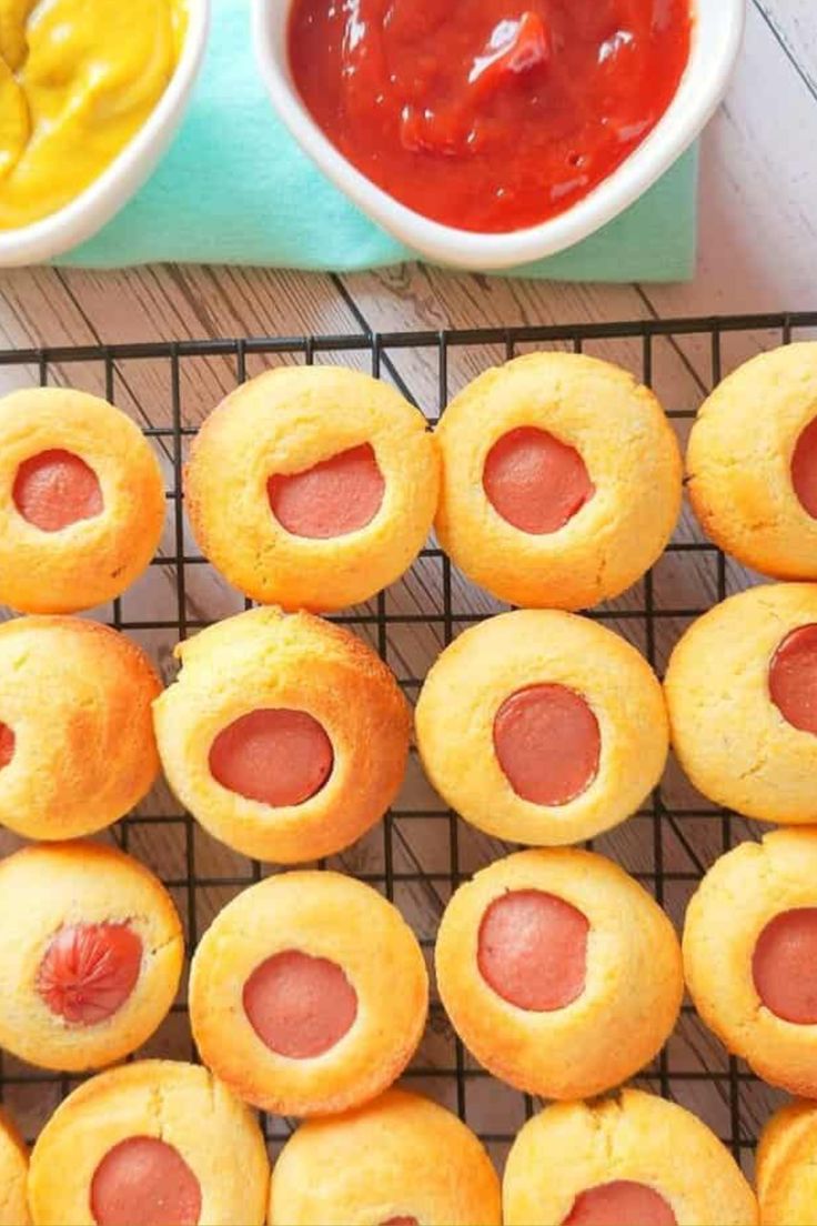 hot dogs are on a cooling rack with ketchup and mustard in the background