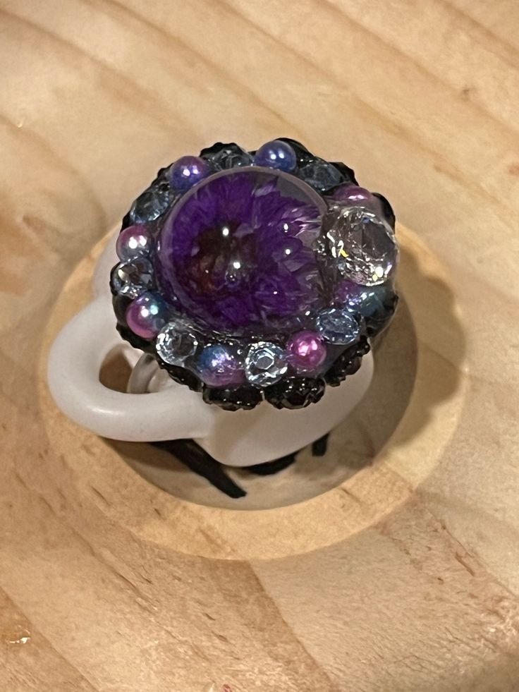 A beautiful zircon and dried purple flower ring surrounded with rhinestones and pearls. Whimsical and fun design. Adjustable, silver plated, fits size 6-8. Purple Flower Ring, Elegant Purple Amethyst Flower Ring, Purple Multi-stone Crystal Ring For Wedding, Purple Flower-shaped Nickel-free Jewelry, Purple Flower-shaped Jewelry With Pressed Flowers, Flower Ring, Purple Flowers, Rings Statement, Dried Flowers