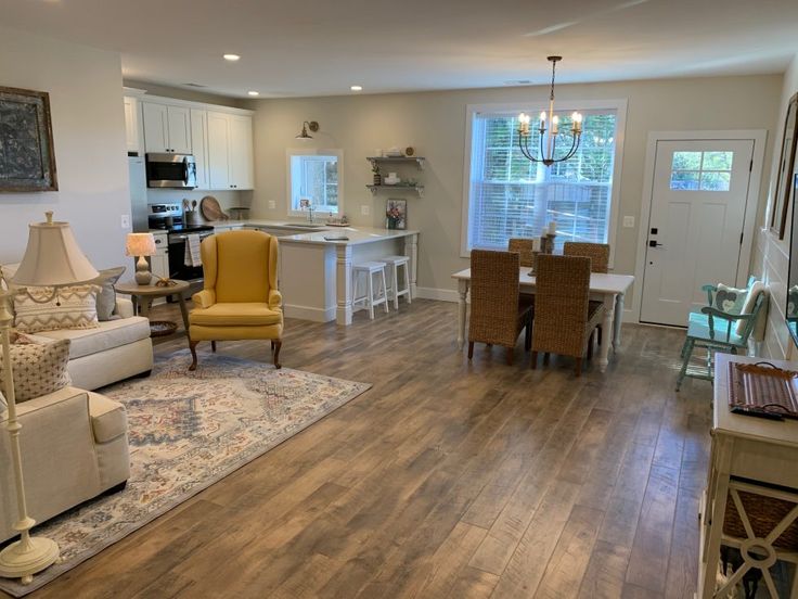 a living room filled with furniture next to a kitchen