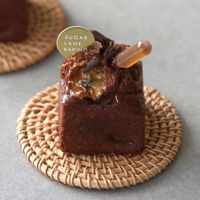 two small brownies sitting on top of a wicker plate next to each other