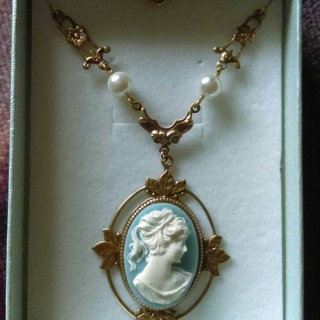 a necklace in a box with an image of a woman