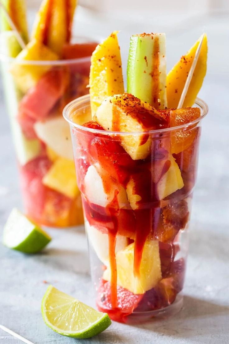 mexican fruit cups with strawberries, celery, and limes in them