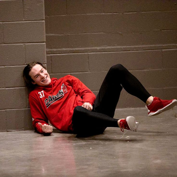 a young man laying on the floor with his feet up and head down, smiling