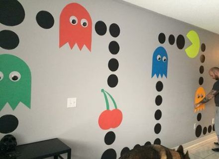 a man standing in front of a wall decorated with different colored monsters and pumpkins