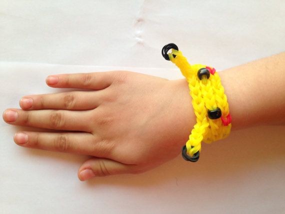 a child's hand wearing a yellow bracelet with black beads