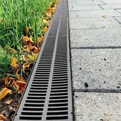 a drain in the ground next to some grass