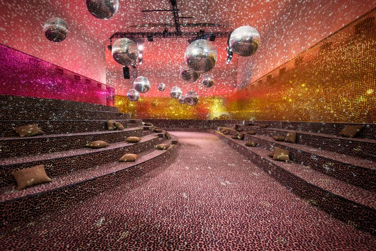 an empty auditorium filled with lots of seats and disco balls hanging from the ceiling above