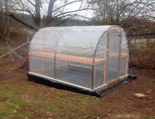 a small greenhouse in the middle of a field