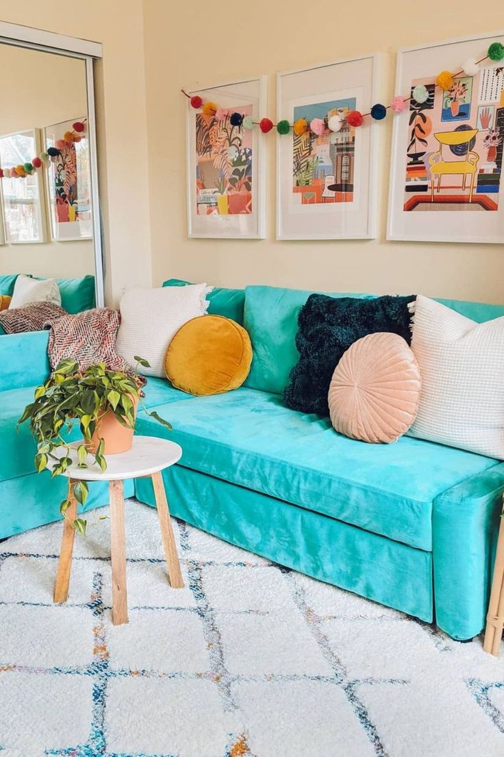 a living room with blue couches and pictures on the wall above them, along with a white rug