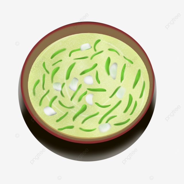 a bowl filled with green vegetables on top of a white table next to a spoon