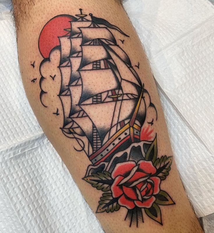 a tattoo with a ship and roses on it