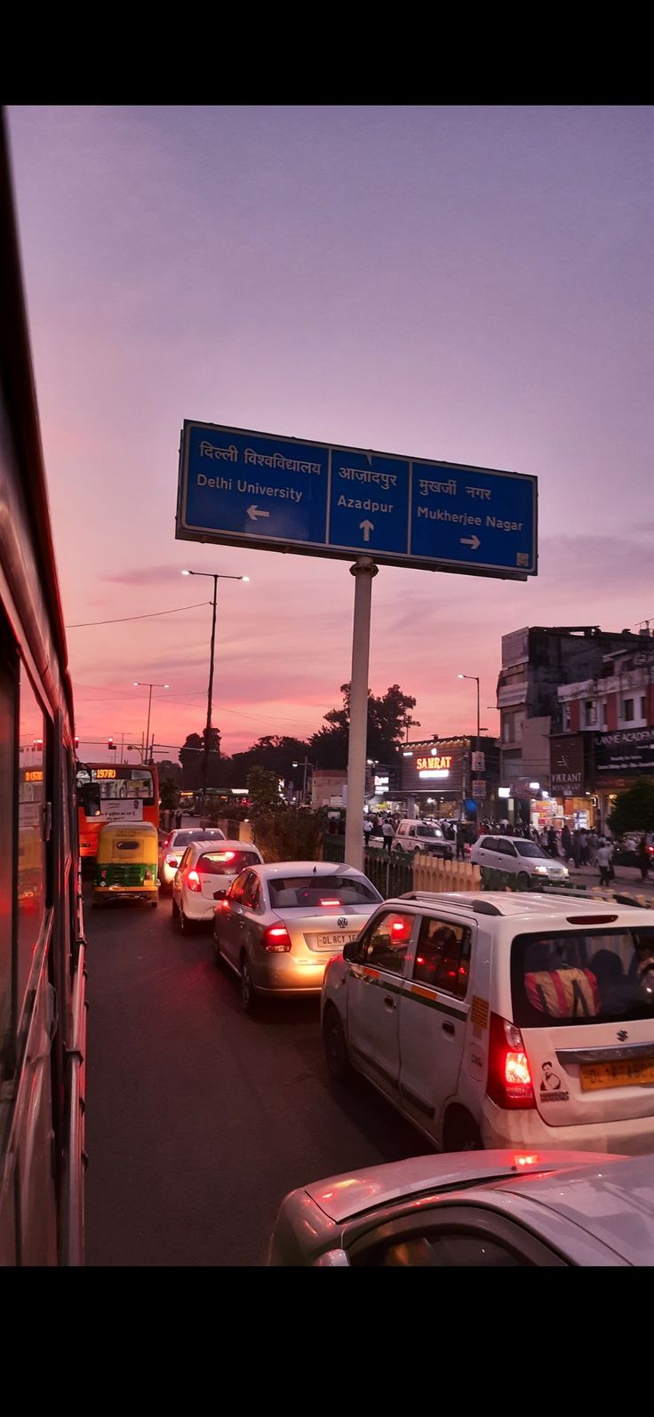 traffic is backed up at an intersection as the sun sets