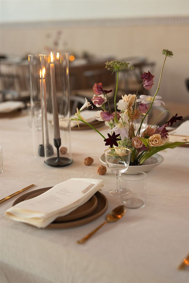 the table is set with flowers and candles