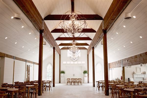 an empty dining hall with chandeliers hanging from the ceiling and tables set up in rows