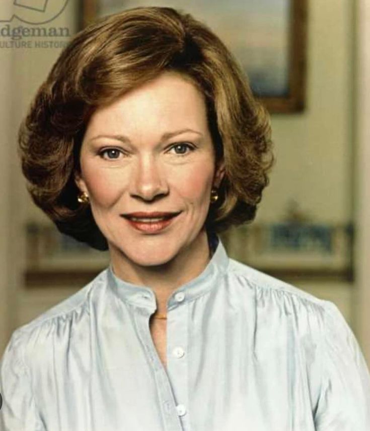 an older woman wearing a blue shirt and smiling