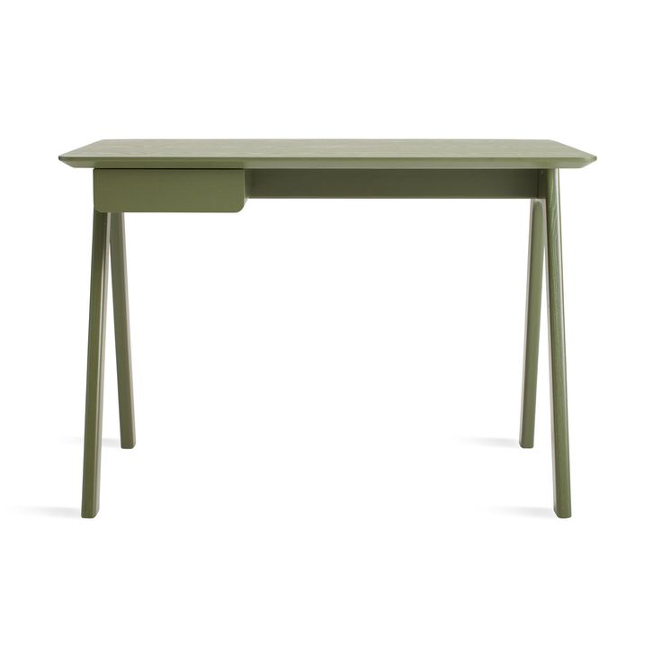 a green desk sitting on top of a white floor next to a wooden table with two legs