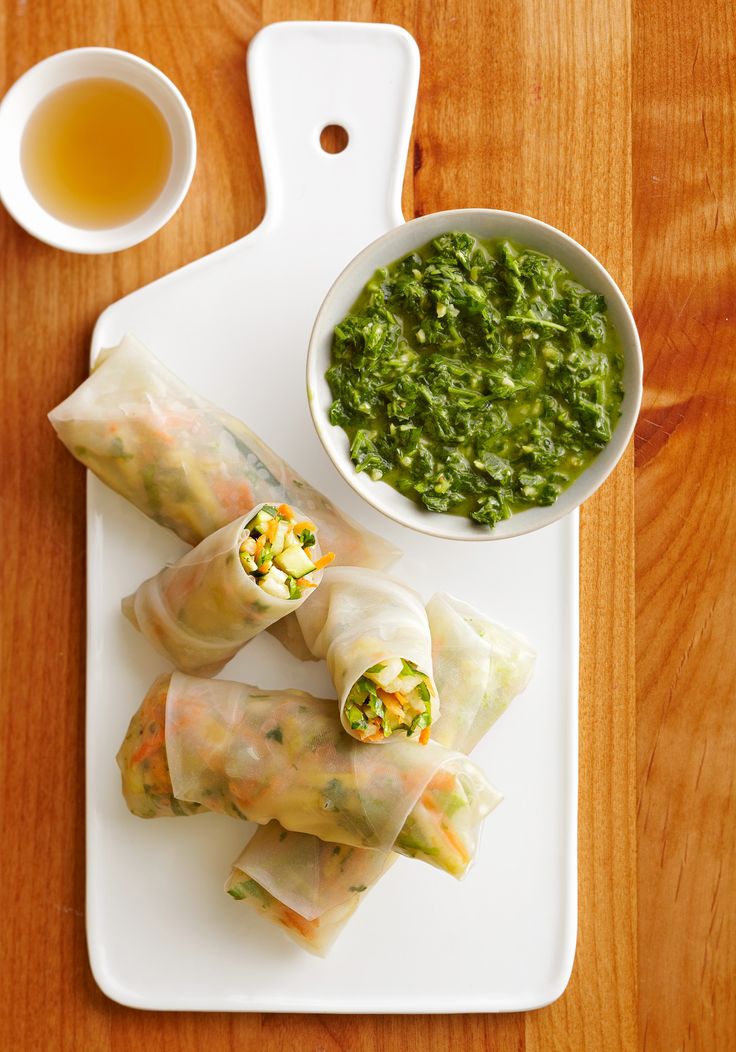 some food is laying out on a white platter next to a bowl of green sauce