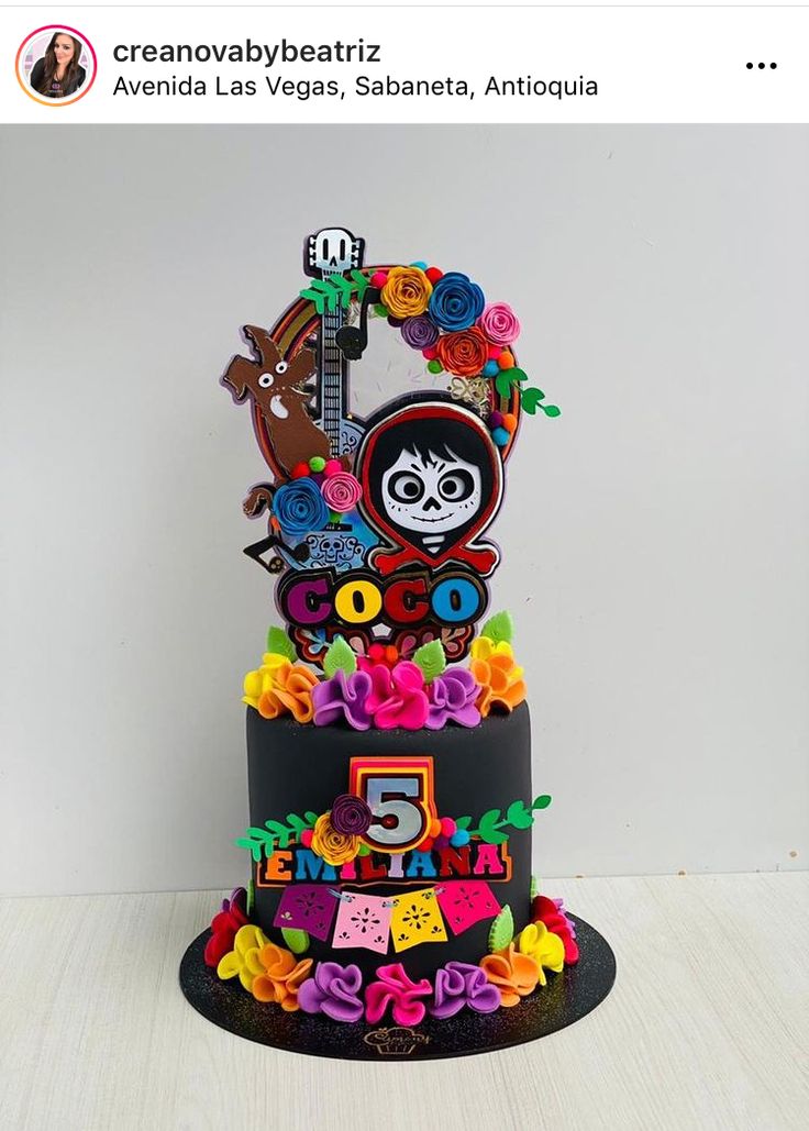 a birthday cake with the number five on it and decorations in multi - colored flowers