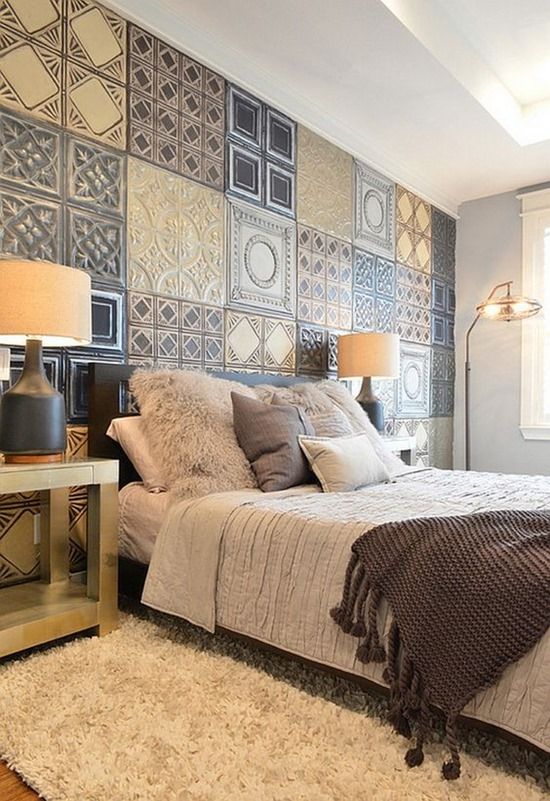 a bed room with a neatly made bed next to a wall covered in decorative tiles