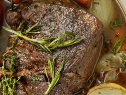 a close up of a plate of food with meat and vegetables