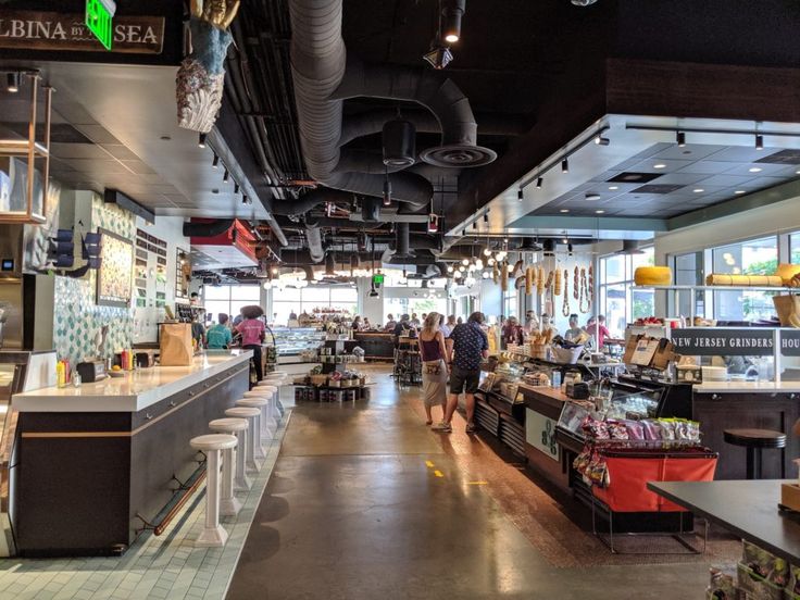 the inside of a restaurant with people walking around