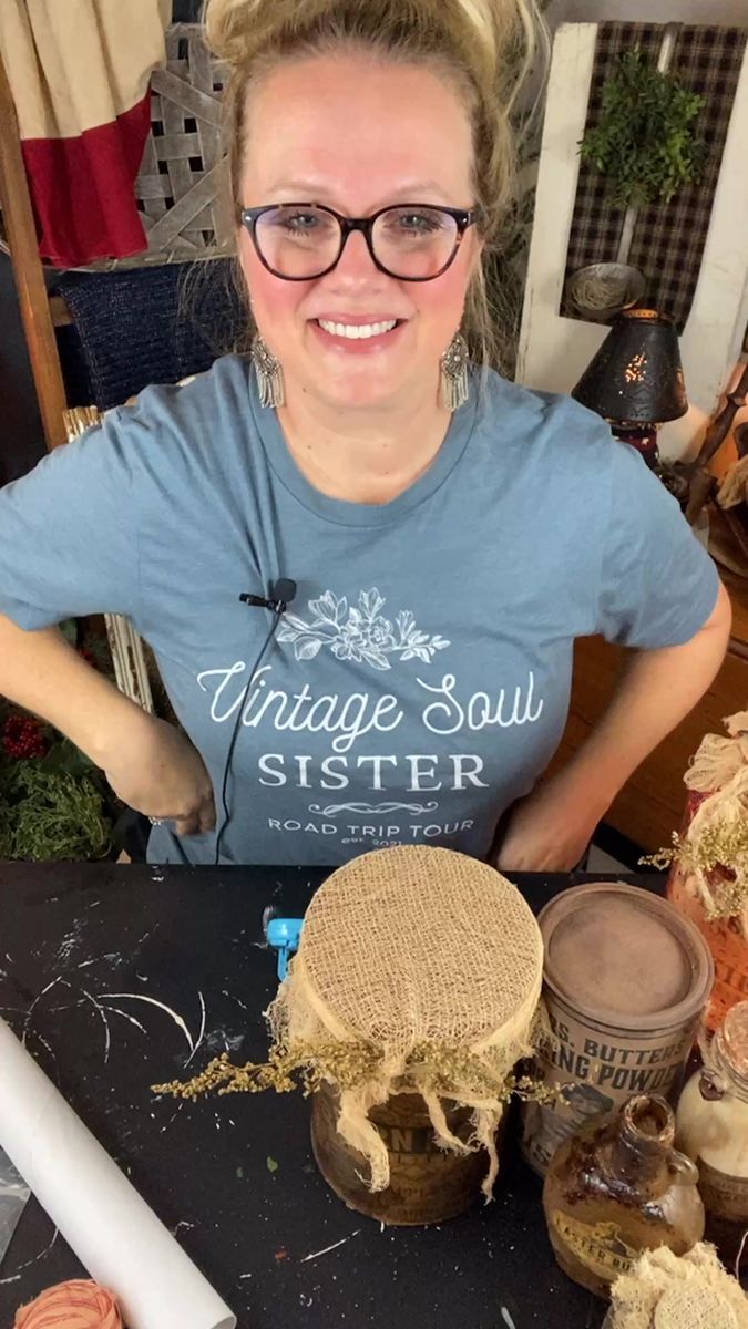 a woman sitting at a table with some type of crafting supplies in front of her