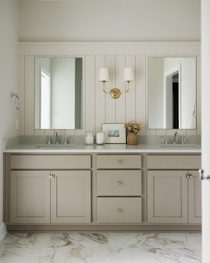 a bathroom with double sinks and two mirrors on the wall next to eachother