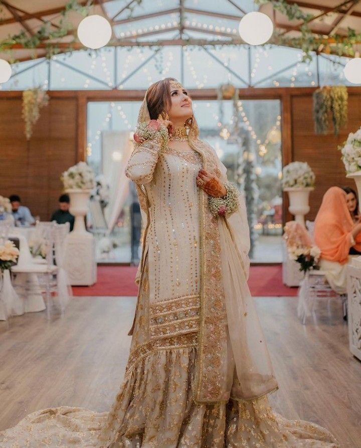 a woman in a white and gold wedding dress