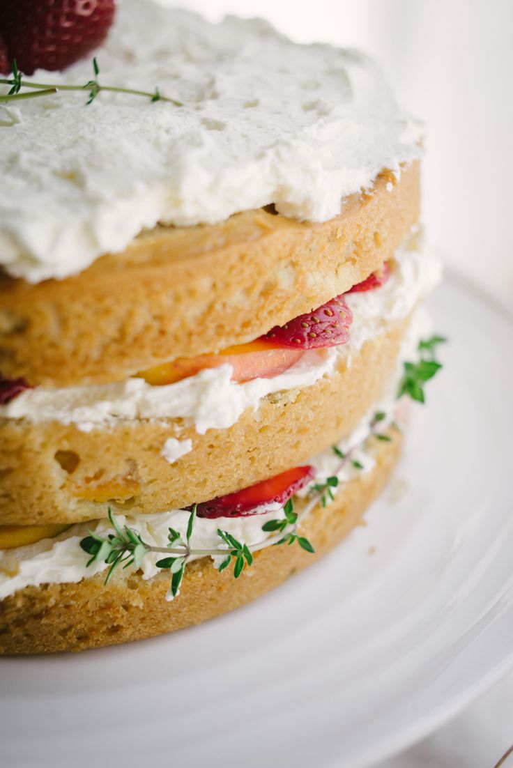 a layered cake with whipped cream and strawberries on top