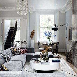 a living room filled with lots of furniture and a chandelier hanging from the ceiling