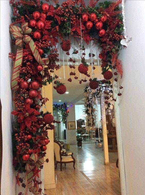 a hallway decorated for christmas with red balls and greenery