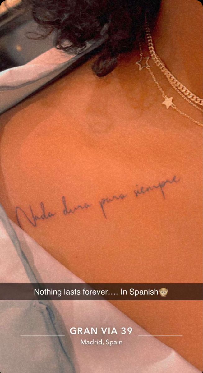 the back of a woman's upper body with writing on her left arm and shoulder