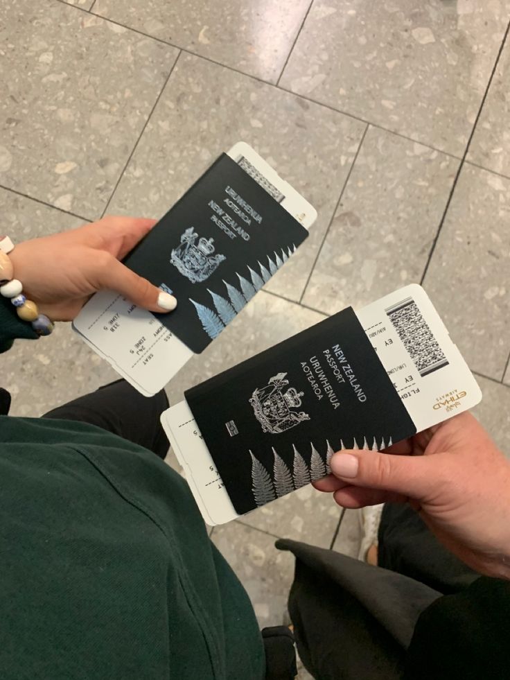 two people holding up their passport cards on the floor