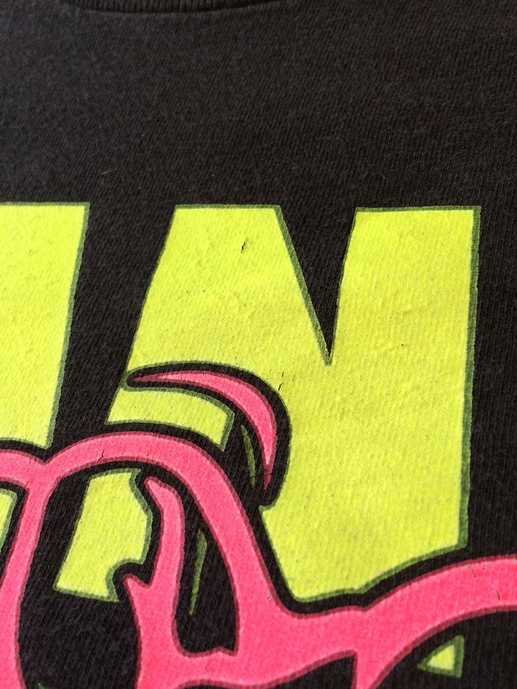 a black t - shirt with pink and yellow letters on the front that says m