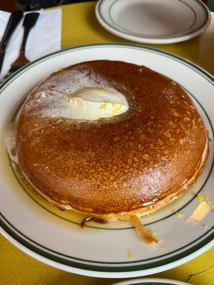 a pancake with an egg on top sits on a plate