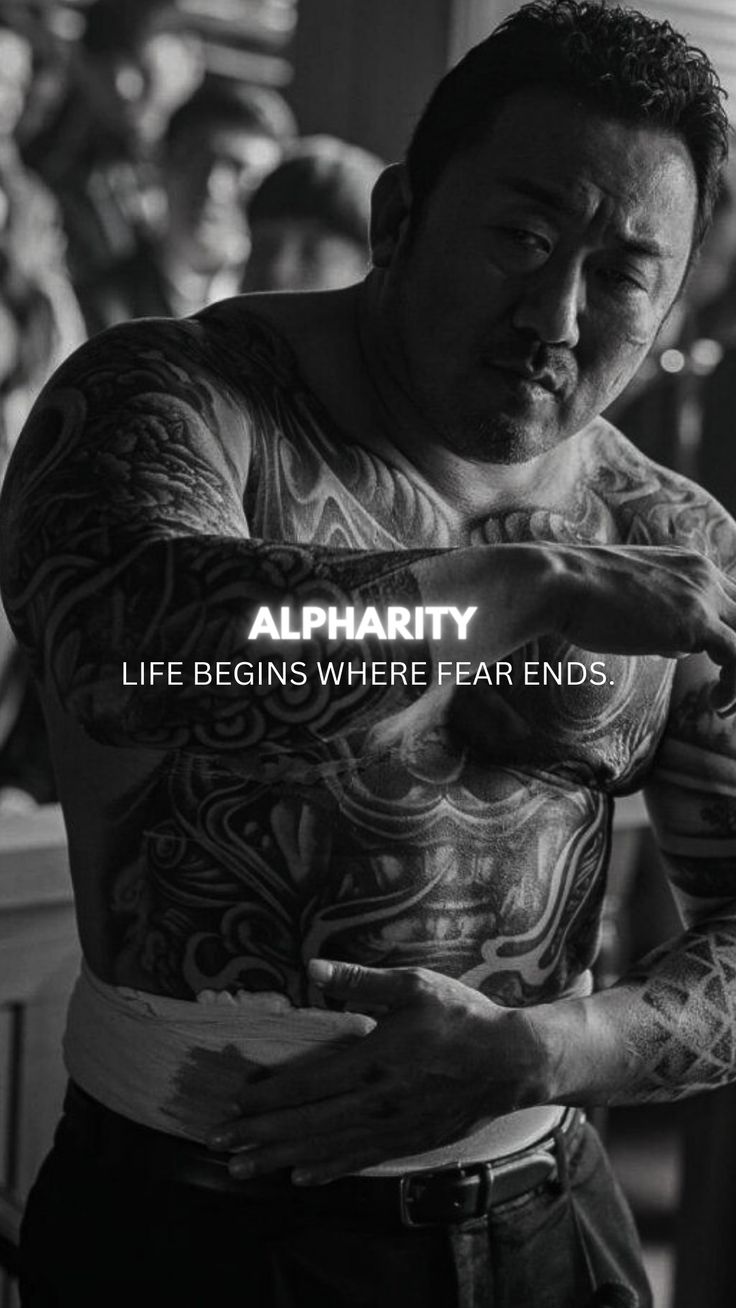 a man with tattoos on his chest pointing at something in front of him and the caption alpharitty life begins where fear ends