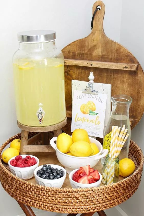 a basket with lemons, strawberries, blueberries and raspberries on it