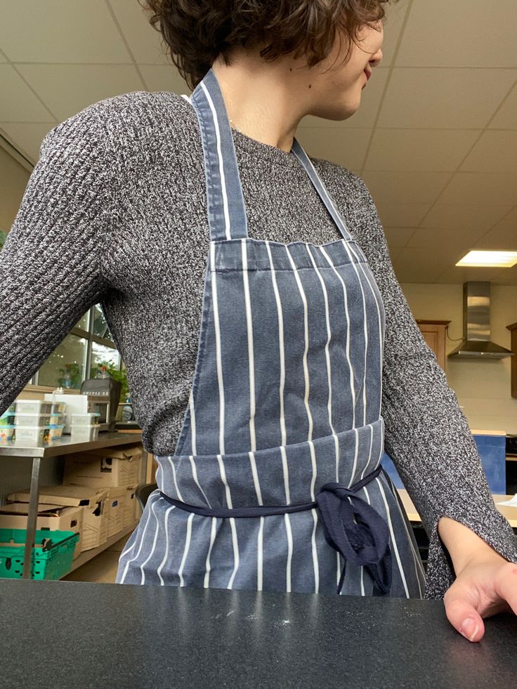 a woman in an apron is standing at the counter