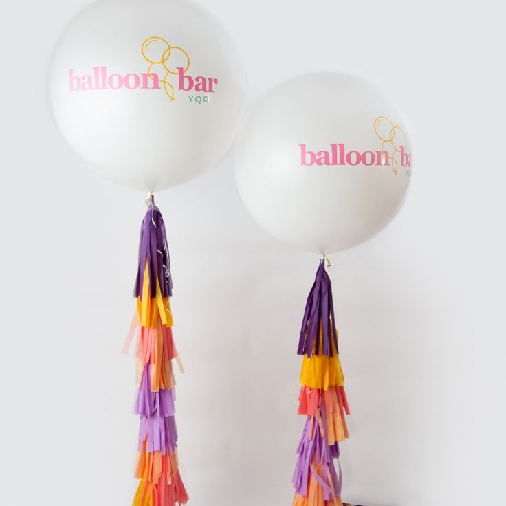 two balloons with tassels attached to them