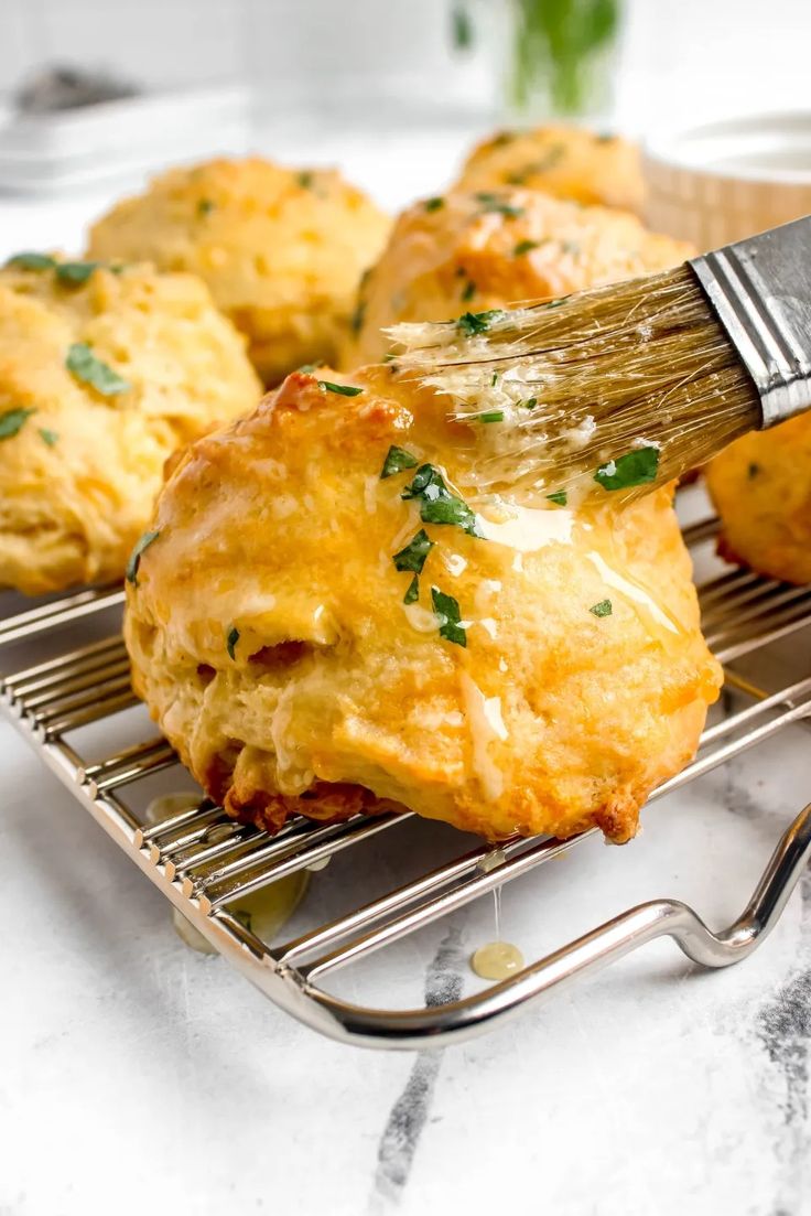 a spatula being used to brush up some food on a wire rack with cheese and parmesan