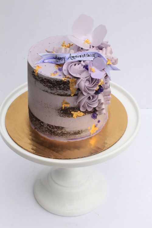 a white cake with purple and gold decorations