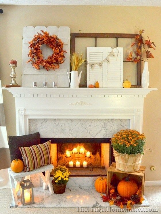 a living room filled with furniture and a fire place covered in pumpkins next to a window