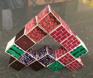 a rubik cube made out of red, green and purple tiles on a black table