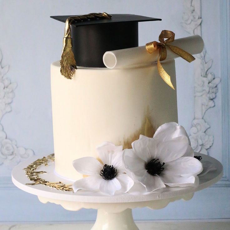 a graduation cake with white flowers on top