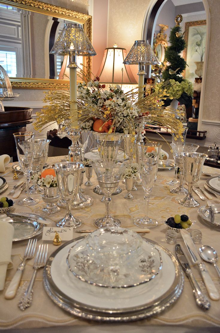 the table is set with silverware and flowers in glass vases, candlesticks, and napkins