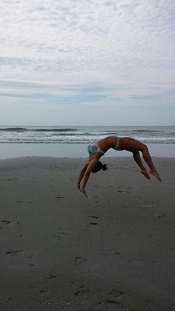 a person jumping in the air on a beach