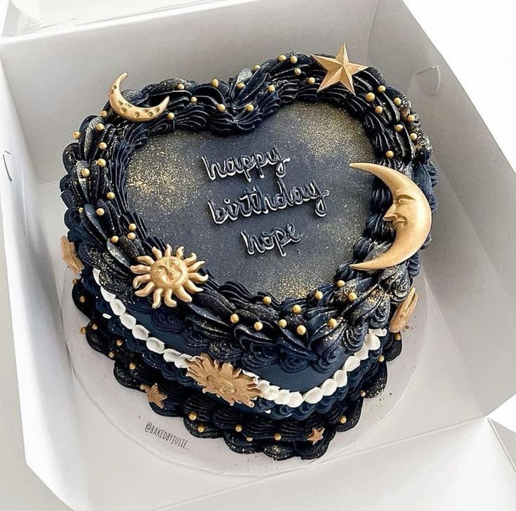 a heart shaped cake in a box with writing on the top and stars around it