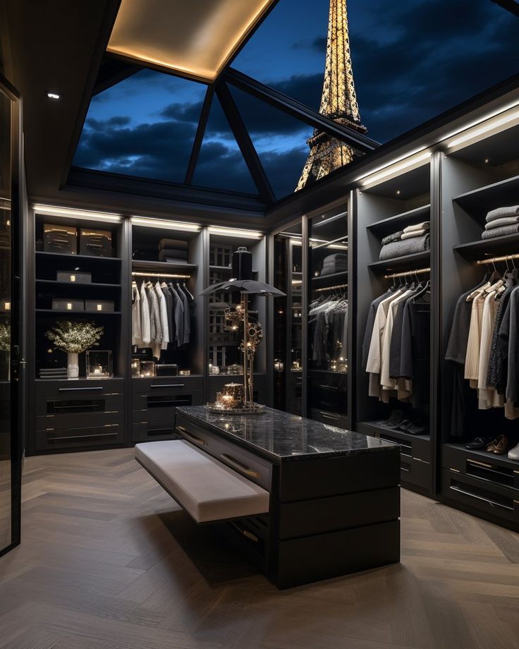 a walk - in closet with clothes on hangers and an illuminated eiffel tower in the background