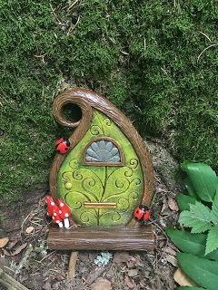 a green fairy house sitting in the grass